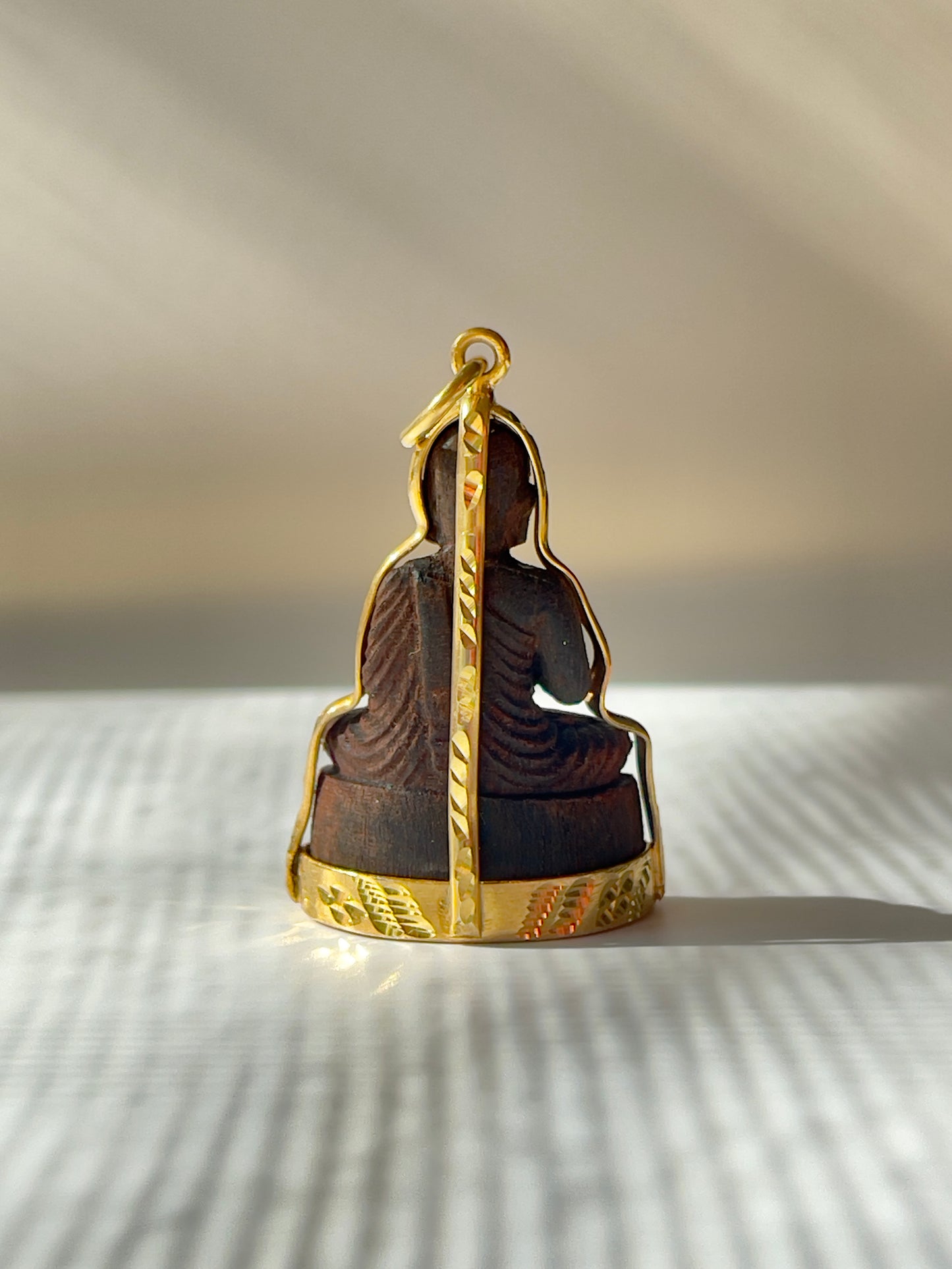 Back view of Wooden Khmer style Buddha in a gold plated mounting. 