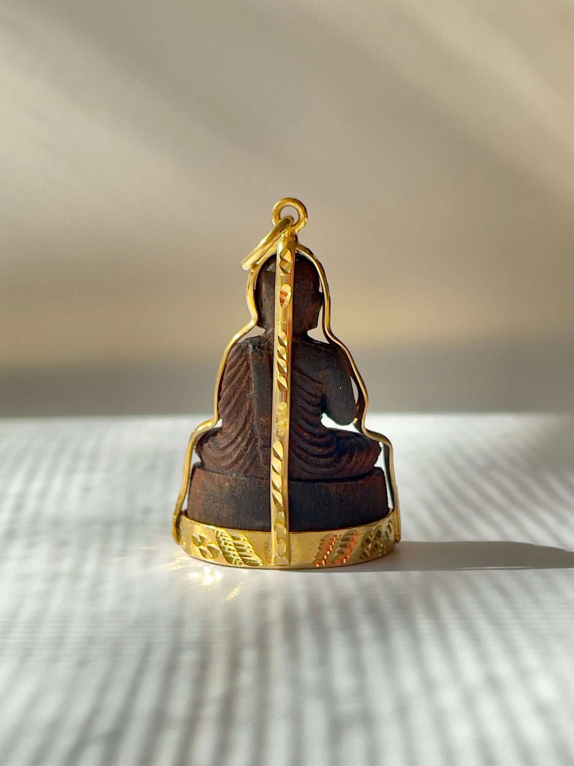 Back view of Wooden Khmer style Buddha in a gold plated mounting. 